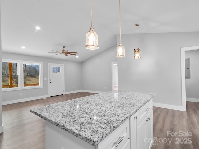 kitchen with light wood-style flooring, white cabinetry, open floor plan, electric panel, and pendant lighting