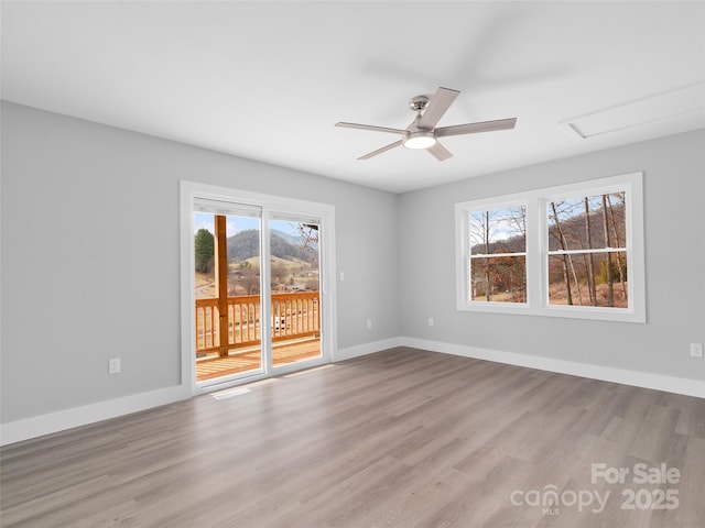 unfurnished room with baseboards, light wood-style floors, and a healthy amount of sunlight