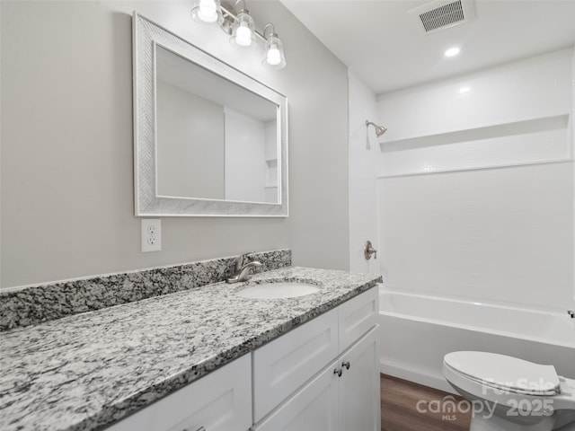 full bathroom featuring visible vents, toilet, wood finished floors,  shower combination, and vanity