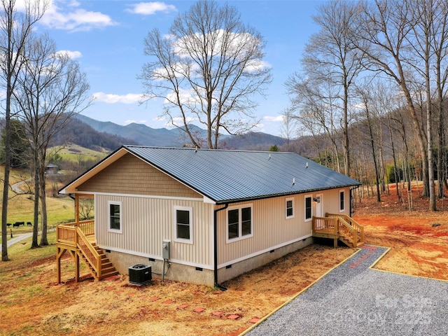 view of side of property with stairs, metal roof, crawl space, and a mountain view