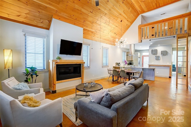 living room with wooden ceiling, baseboards, high vaulted ceiling, and a glass covered fireplace