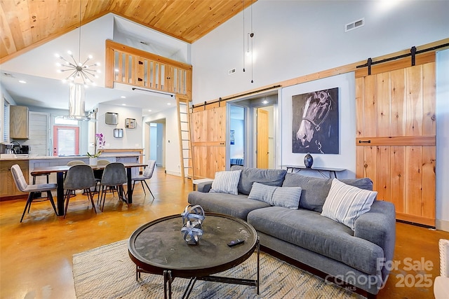 living room with finished concrete flooring, a barn door, visible vents, wood ceiling, and high vaulted ceiling