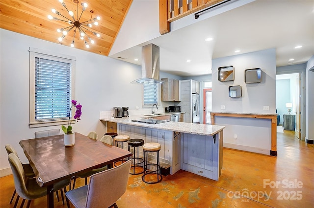 kitchen with a breakfast bar, island exhaust hood, recessed lighting, finished concrete floors, and a peninsula