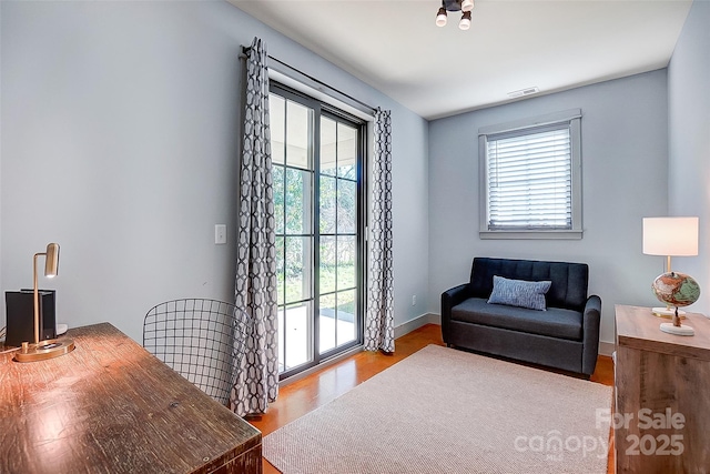 interior space featuring visible vents, baseboards, a wealth of natural light, and wood finished floors