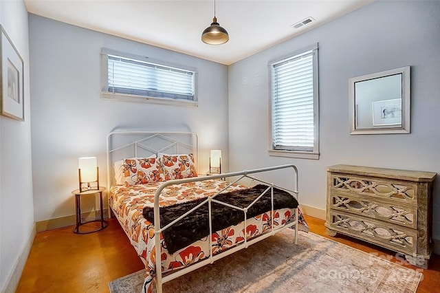 bedroom featuring visible vents, baseboards, and wood finished floors