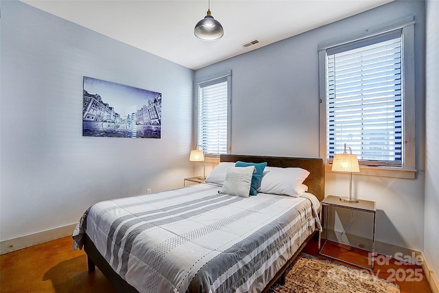 bedroom featuring visible vents, baseboards, and multiple windows