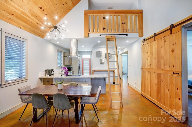 dining area featuring high vaulted ceiling, a barn door, and baseboards