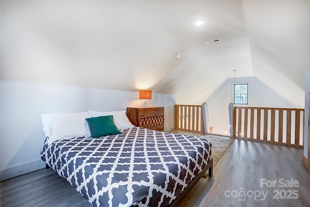 bedroom featuring lofted ceiling, wood finished floors, and visible vents