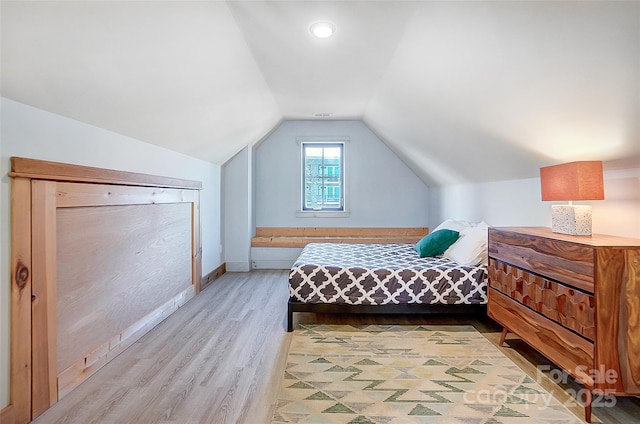 bedroom featuring lofted ceiling, light wood-style floors, and baseboards