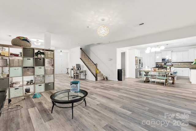 living room featuring light wood-style floors and stairs