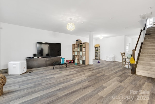 living area featuring stairs and wood finished floors