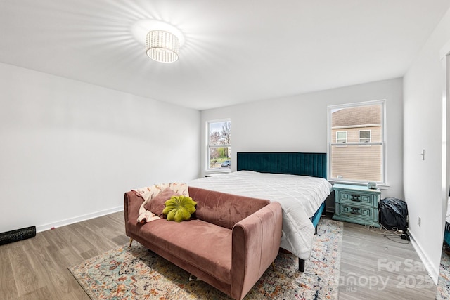 bedroom with light wood-style flooring and baseboards