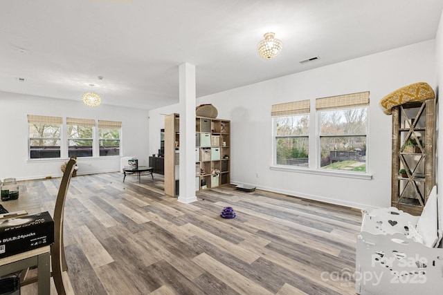 workout area featuring visible vents, baseboards, and wood finished floors