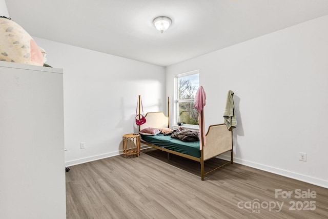 bedroom with baseboards and wood finished floors