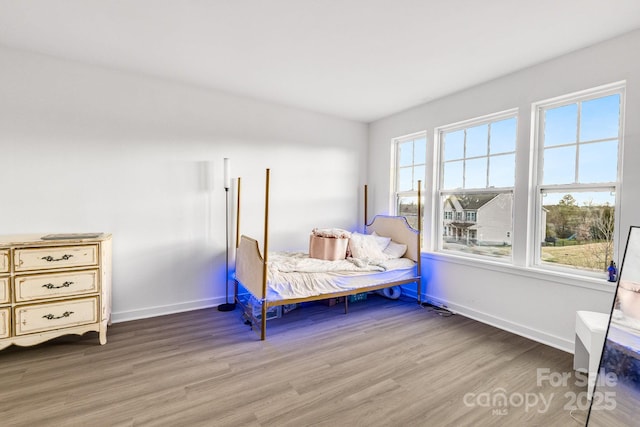 bedroom featuring wood finished floors and baseboards