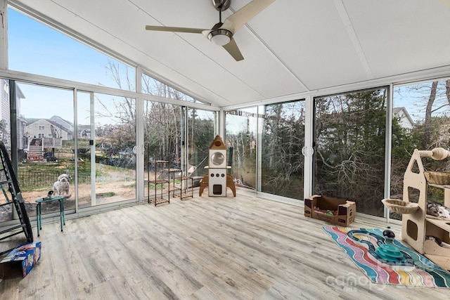 unfurnished sunroom featuring ceiling fan, plenty of natural light, and vaulted ceiling