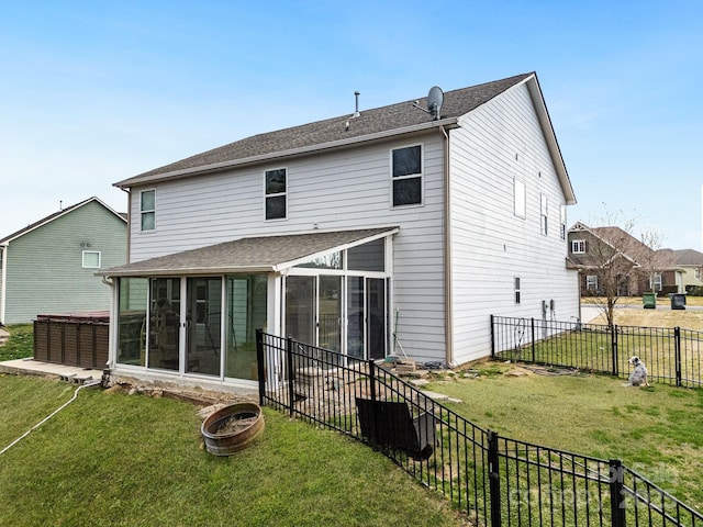 back of property with a sunroom, a fenced backyard, and a lawn