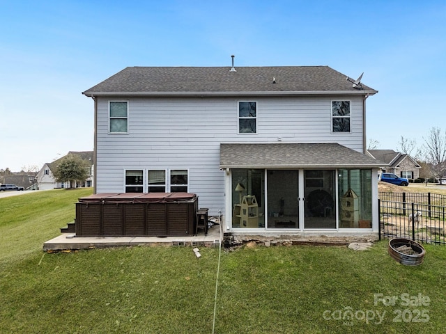 back of house with a hot tub, a shingled roof, a lawn, a sunroom, and fence