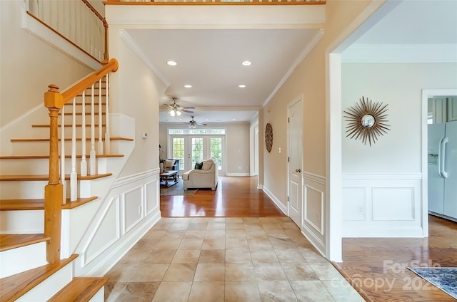 entrance foyer with a wainscoted wall, stairway, ornamental molding, a decorative wall, and recessed lighting