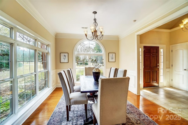 dining space featuring a healthy amount of sunlight, a notable chandelier, and light wood-style flooring