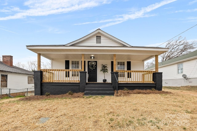 bungalow-style home with covered porch and fence