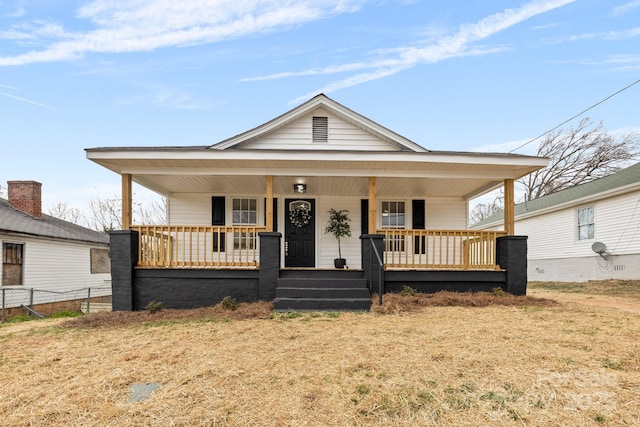 bungalow-style home with covered porch and fence