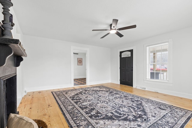 foyer featuring baseboards, wood finished floors, and a ceiling fan