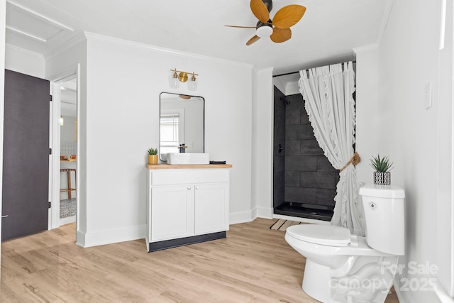 full bath featuring crown molding, toilet, wood finished floors, and a tile shower