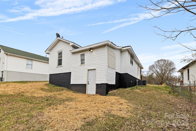 view of side of home featuring fence and central AC