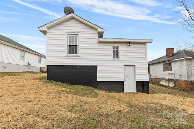 back of house with a lawn