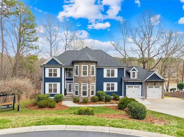 view of front of property featuring a front yard, a shingled roof, concrete driveway, a garage, and stone siding