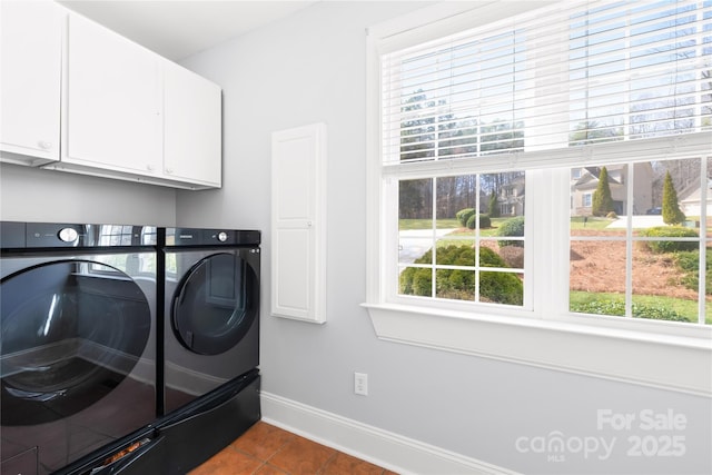 laundry room featuring separate washer and dryer, dark tile patterned flooring, cabinet space, and baseboards