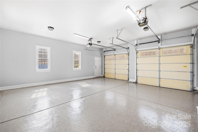 garage featuring a garage door opener and baseboards