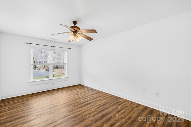 unfurnished room with visible vents, baseboards, dark wood finished floors, and a ceiling fan