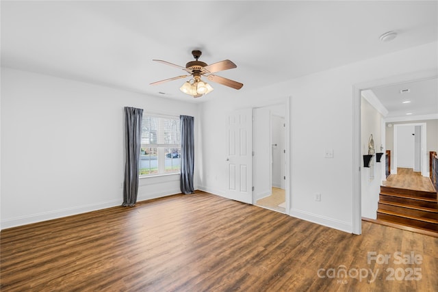 unfurnished bedroom featuring a ceiling fan, visible vents, wood finished floors, and baseboards