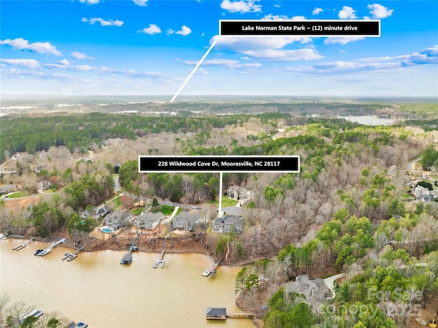 drone / aerial view featuring a water view and a wooded view