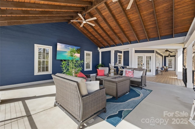 view of patio / terrace with a ceiling fan, a deck, french doors, and an outdoor living space with a fire pit