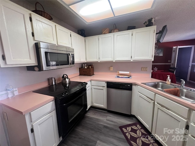 kitchen featuring a sink, stainless steel appliances, light countertops, and white cabinetry