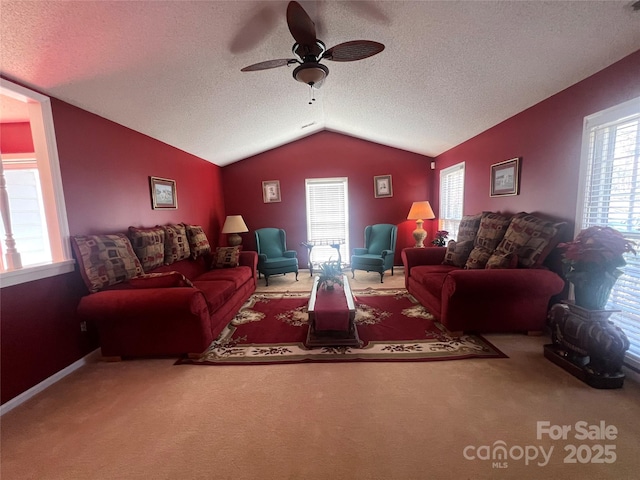 carpeted living area featuring lofted ceiling, baseboards, a ceiling fan, and a textured ceiling