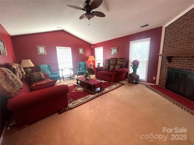 carpeted living area featuring a fireplace, lofted ceiling, visible vents, ceiling fan, and a textured ceiling