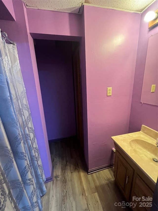 full bathroom featuring a textured ceiling, wood finished floors, and vanity