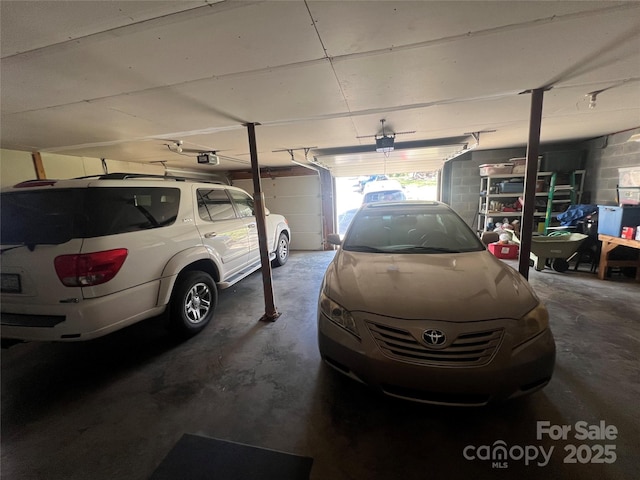 garage featuring concrete block wall and a garage door opener