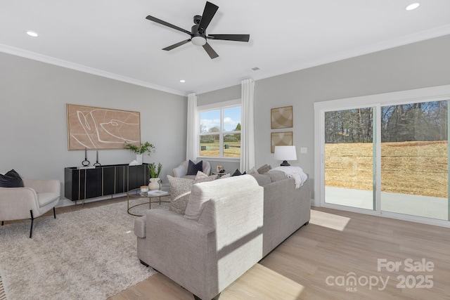 living room featuring a ceiling fan, recessed lighting, crown molding, and light wood finished floors