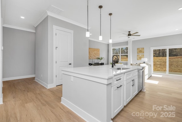 kitchen with crown molding, a sink, light wood-style flooring, and white cabinets