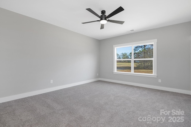 carpeted empty room featuring visible vents, ceiling fan, and baseboards