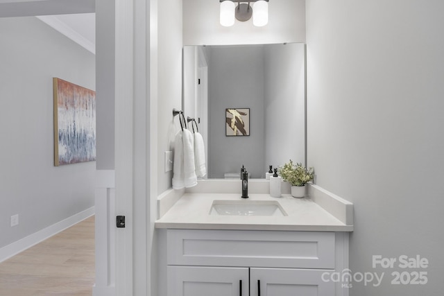 bathroom featuring baseboards, wood finished floors, and vanity