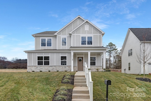 view of front of home featuring stone siding, a front lawn, and board and batten siding