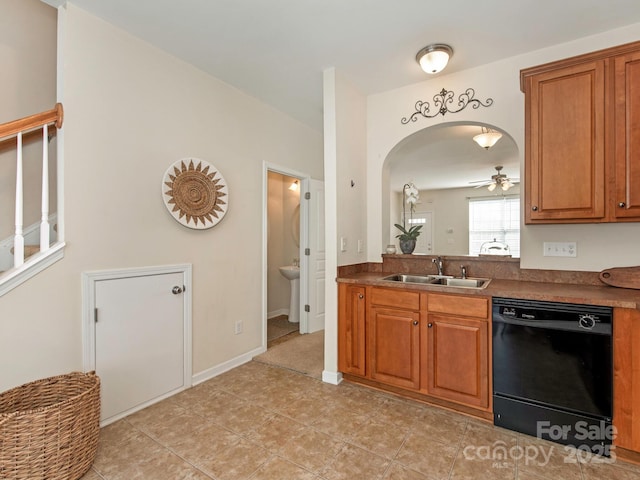 kitchen with brown cabinetry, dark countertops, black dishwasher, and a sink