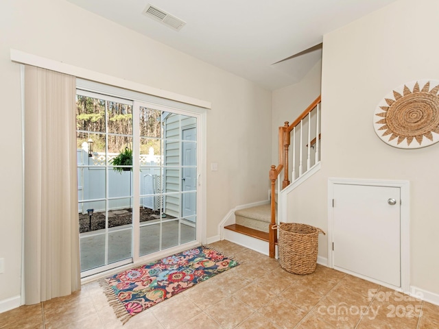 doorway featuring tile patterned floors, visible vents, stairs, and baseboards