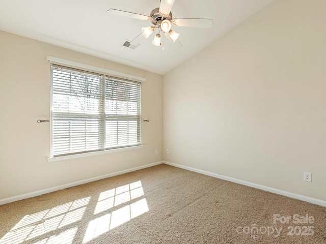 spare room with carpet, baseboards, and vaulted ceiling